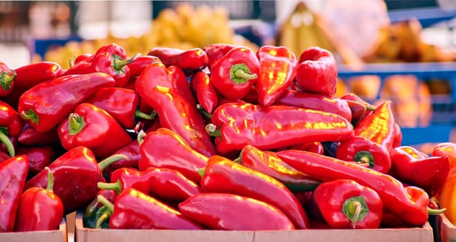 Red chili peppers with vegetables in the market. Tomatoes and peppers are selected by the buyer at the market.