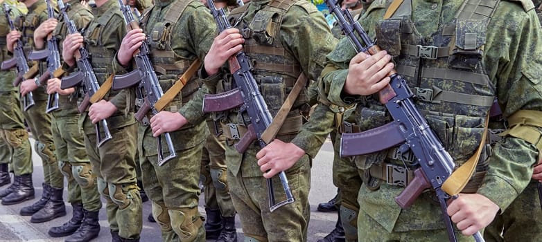 Soldiers stand in line with rifles. Soldiers shoulder to shoulder during the parade.