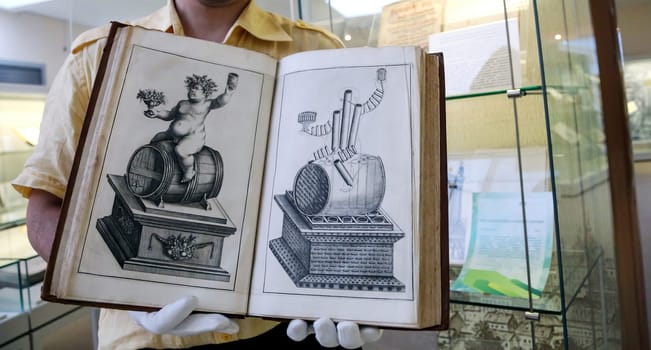 An old book in a scientist's hands, close-up. Christian antique book in the hands of a librarian.