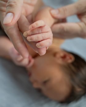 A newborn boy holds his mother's finger. Close-up of hands