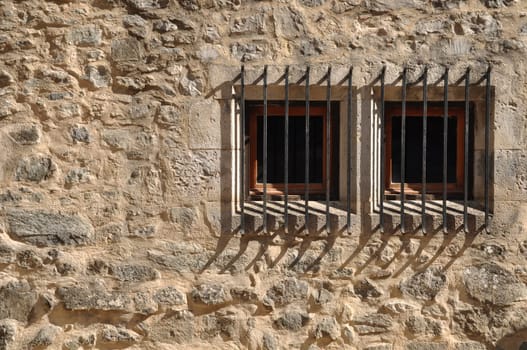 ancient windows of a medieval building with bars