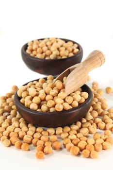 yellow peas and a shovel against white background