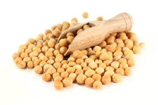 yellow peas and a shovel against white background