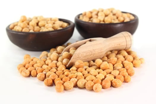 yellow peas and a shovel against white background