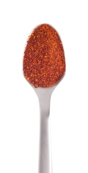 piri-piri flakes spice on a stainless steel spoon, isolated on white background