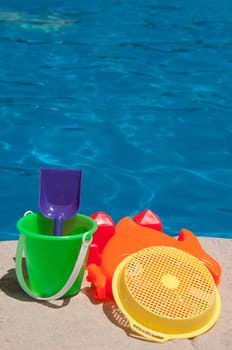 bright and colorful children toys at poolside (family vacations concept)