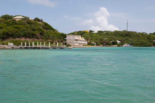 Antigua Long Bay, gorgeous seascape view surrounded by tropical nature and some typical houses