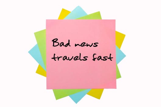 text "Bad news travels fast"" written by hand font on bunch of colored sticky notes"