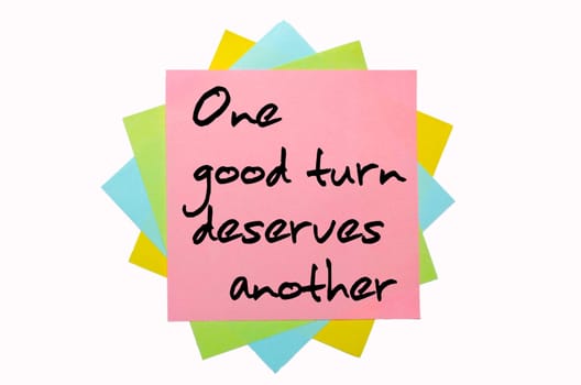 text " One good turn deserves another "" written by hand font on bunch of colored sticky notes"