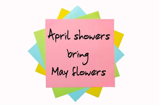 text "April showers bring May flowers"" written by hand font on bunch of colored sticky notes"