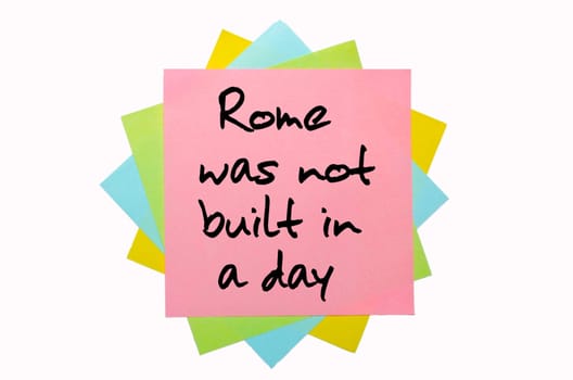 text " Rome was not built in a day "" written by hand font on bunch of colored sticky notes"
