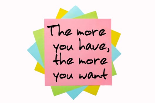 text " The more you have, the more you want "" written by hand font on bunch of colored sticky notes"