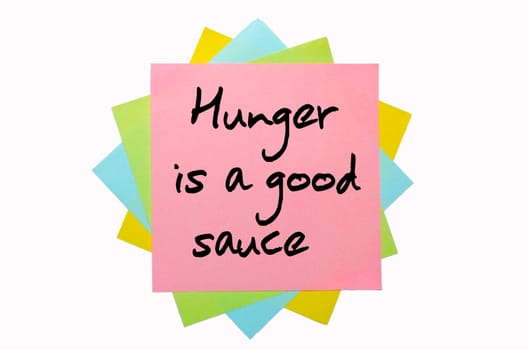 text " Hunger is a good sauce "" written by hand font on bunch of colored sticky notes"