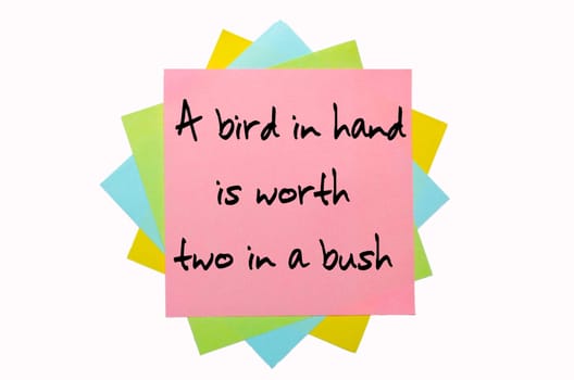 text "A bird in hand is worth two in a bush"" written by hand font on bunch of colored sticky notes"