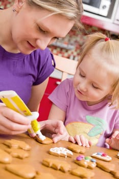 the mother and her daughter decorate ginger bread