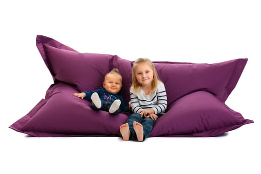 studio shot of two sister sitting on beanbag