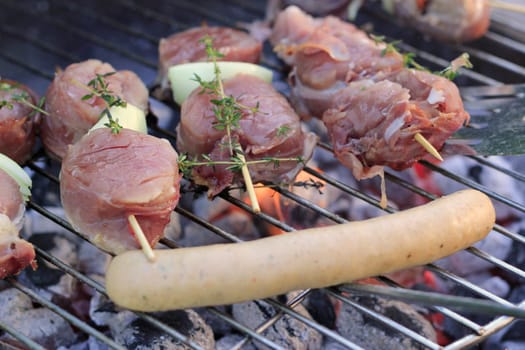 Skewers and a sausage on the grill