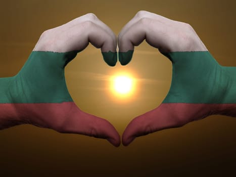 Gesture made by bulgaria flag colored hands showing symbol of heart and love during sunrise