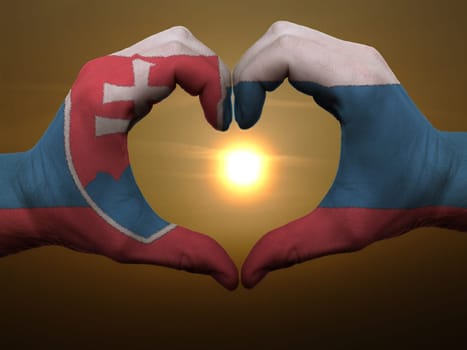 Gesture made by slovakia flag colored hands showing symbol of heart and love during sunrise