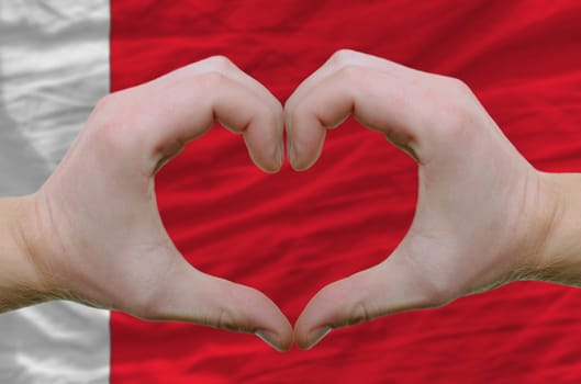 Gesture made by hands showing symbol of heart and love over bahrain flag
