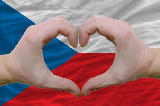 Gesture made by hands showing symbol of heart and love over czech flag