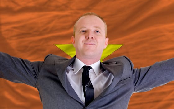 joyful investor spreading arms after good business investment in vietnam, in front of flag
