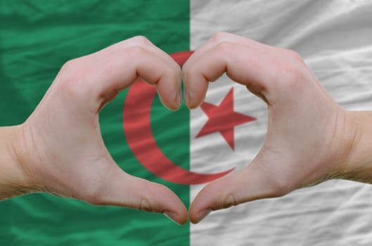 Gesture made by hands showing symbol of heart and love over Afghanistan flag