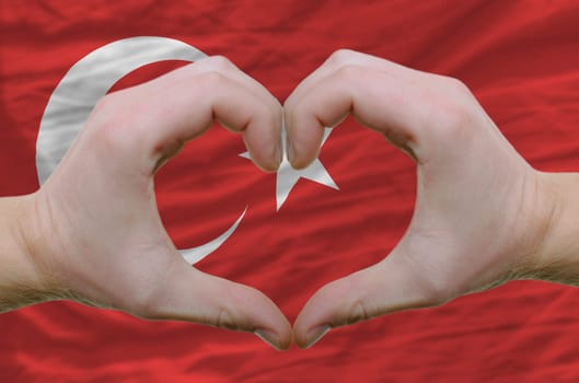 Gesture made by hands showing symbol of heart and love overturkey flag