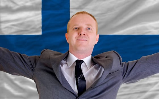 joyful investor spreading arms after good business investment in europe, in front of flag