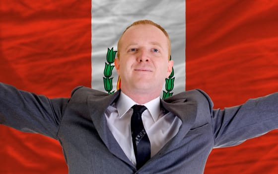 joyful investor spreading arms after good business investment in peru, in front of flag