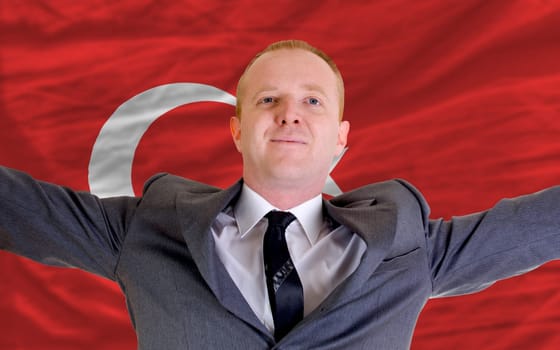 joyful investor spreading arms after good business investment in turkey, in front of flag