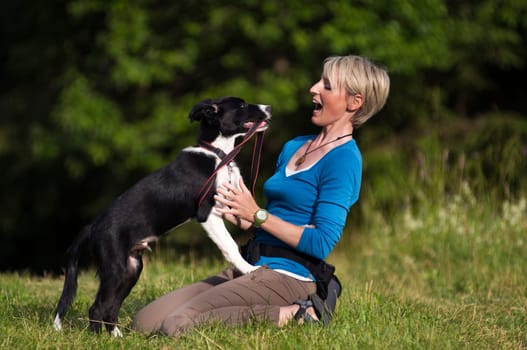 Young woman playing with border collie dog outdoor