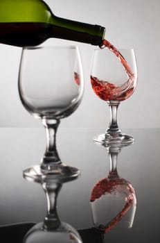 Red wine pouring into glass close up