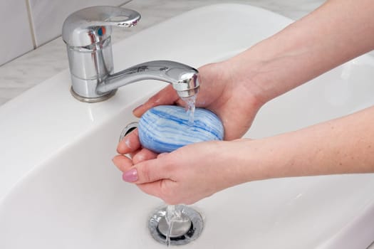 human hands being washed under stream of pure water