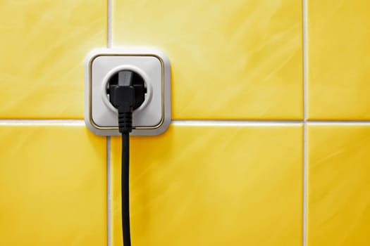 Wall outlet with a electric plug in a bathroom