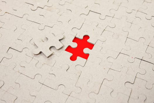 papper puzzle background with one red piece missing