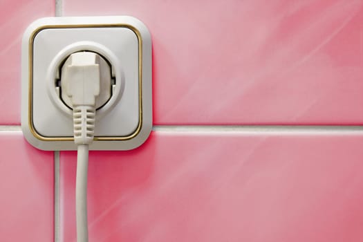 white outlet with a electric plug in a bathroom