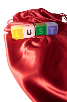 lust written with blocks on a silk nightie against white background