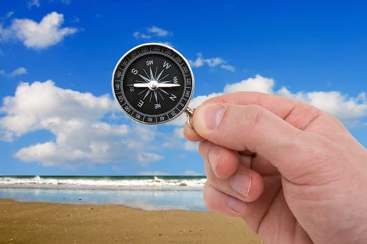 travel concept. human hand with compass on the sea background