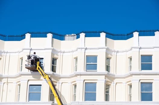 A man cleaning sash windows from outside in the UK