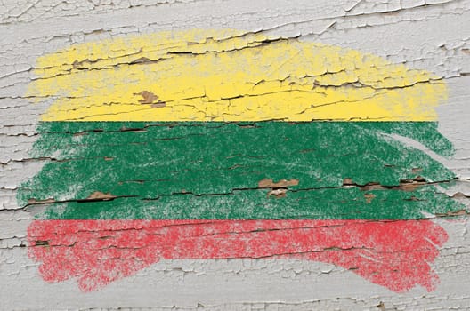 Chalky lithuanian flag painted with color chalk on grunge wooden texture