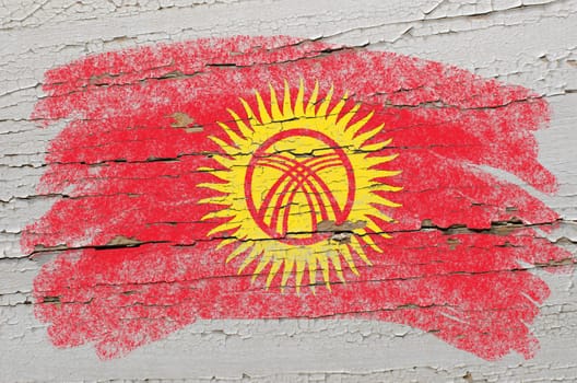 Chalky kyrghyzstan flag painted with color chalk on grunge wooden texture