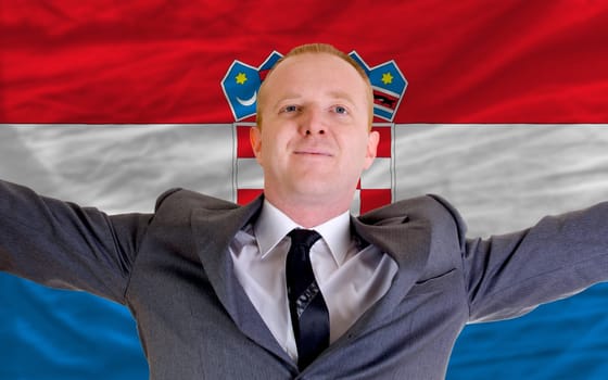 joyful investor spreading arms after good business investment in croatia, in front of flag