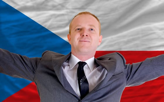 joyful investor spreading arms after good business investment in czech, in front of flag