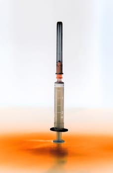 Shaded and isolated medical syringe standing head up