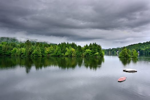 A lake during a rain storm. There are dark, ominous rain clouds overhead