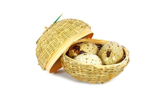 Three eggs of Japanese quail in a little basket isolated on white