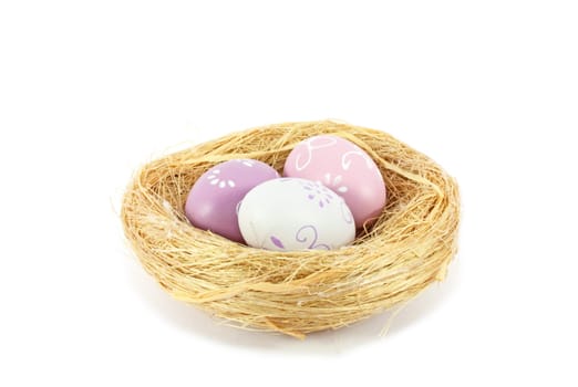 bird nest with three colored eggs isolated on white