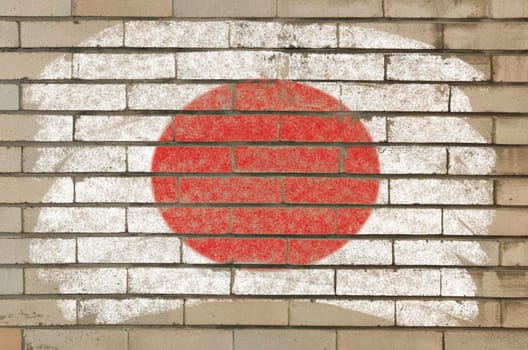 Chalky japanese flag painted with color chalk on grunge old brick wall