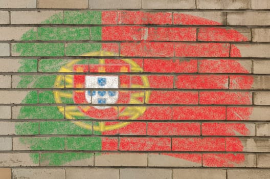 Chalky portugese flag painted with color chalk on grunge old brick wall